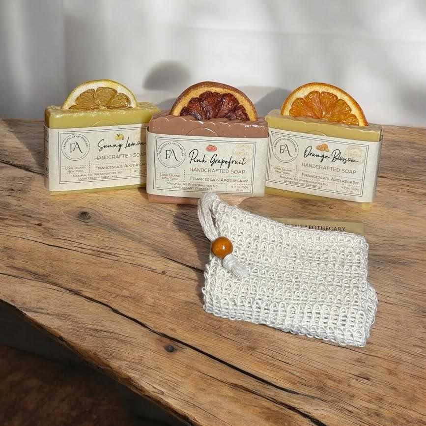 Natural fruit bundle with lemon, grapefruit, and orange handcrafted soaps on a wooden surface.