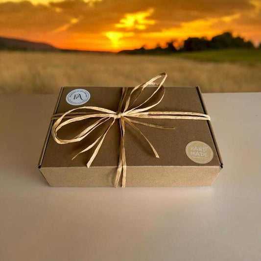 Small gift set box with ribbon on a table, sunset view in the background.
