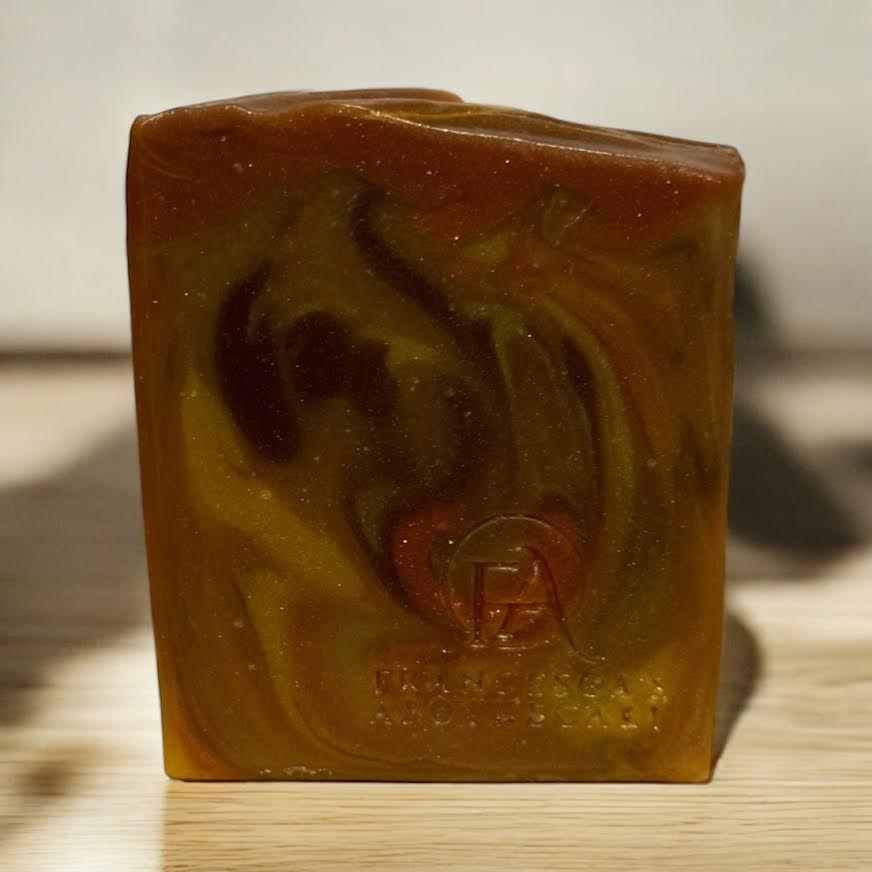 Luxurious spicy fruit soap with vibrant orange and spice swirls, packaged in an elegant white box.