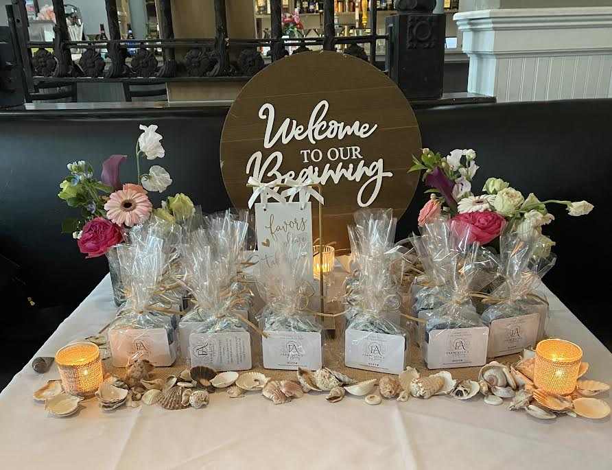 Custom wedding shower favors with spearmint and eucalyptus scented soaps, decorated in blue and white with shell accents and biodegradable glitter, displayed elegantly.