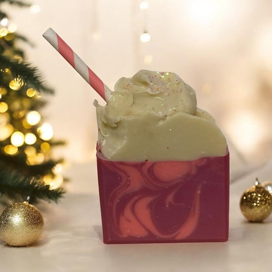 Raspberry Float Soap with biodegradable glitter on a festive background, featuring a whimsical design with pink and white swirls.