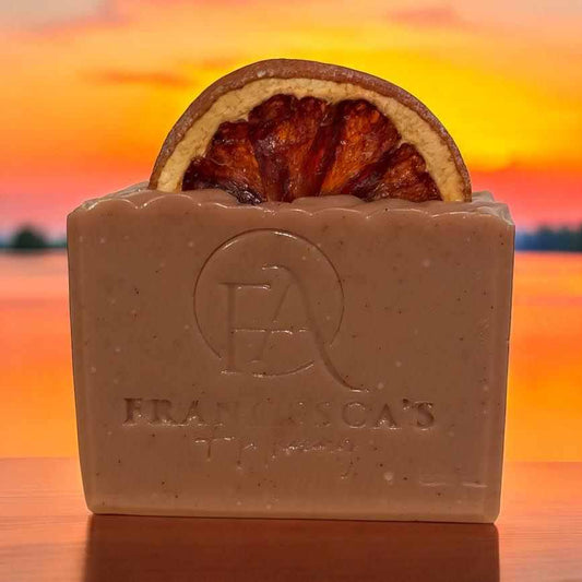 Natural fruit bundle soap with dehydrated orange slice and sunset background.