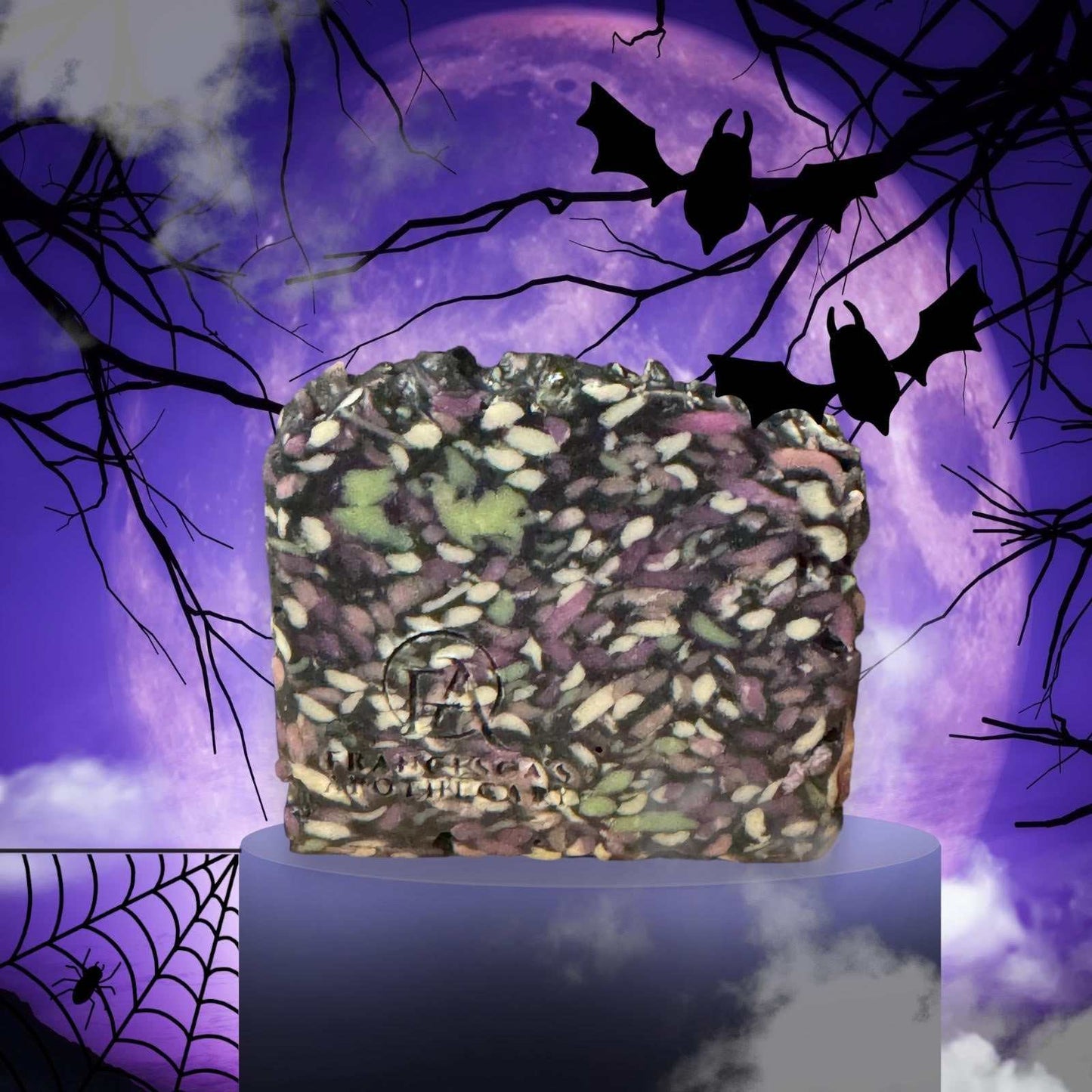 Twilight Moon Artisan Soap with black, purple, and green swirls on a pedestal against a spooky purple moon background with bats and spider webs.