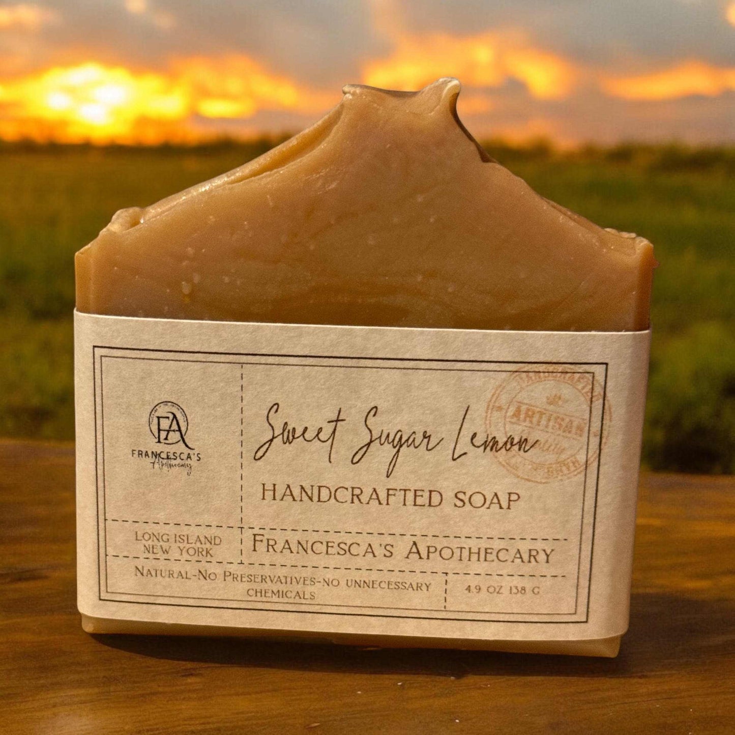 Sweet Sugar Lemon Soap with natural ingredients and candy scent on a wooden surface against a sunset background.
