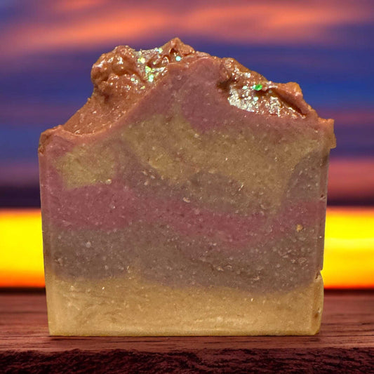 Sunset Pink Beach Soap with Walnut Shell Powder, featuring sea salt, citrus, and ocean orchid fragrance, against a sunset backdrop.