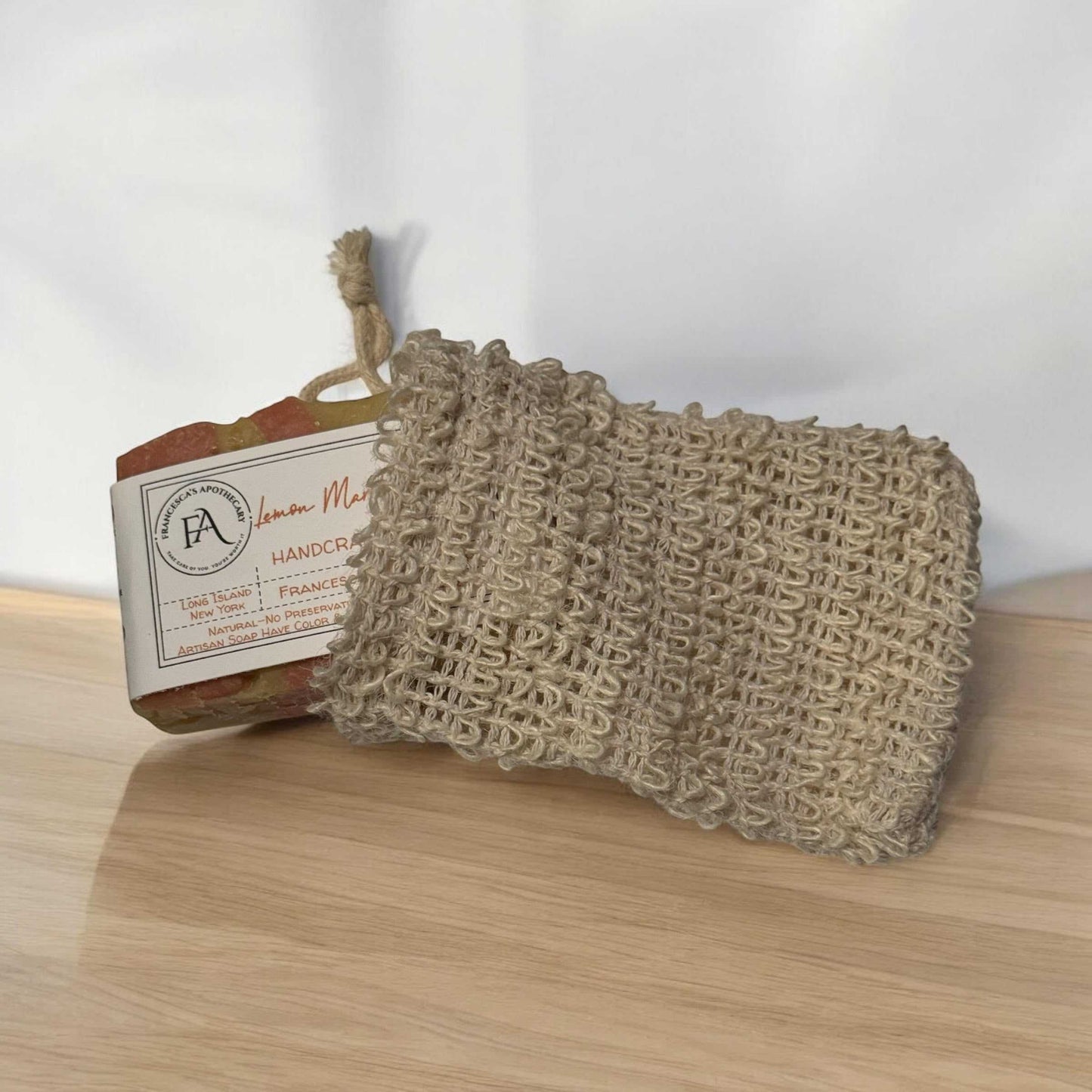 Lemon Marble Rose Soap with soap saver bag on wooden surface.