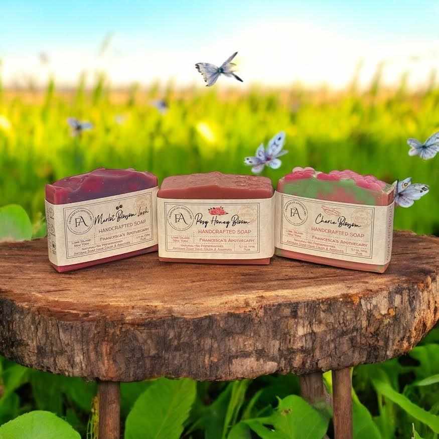 FLORAL FRUITY summer scent soap bundle placed outdoors on a wooden surface with a green field background.